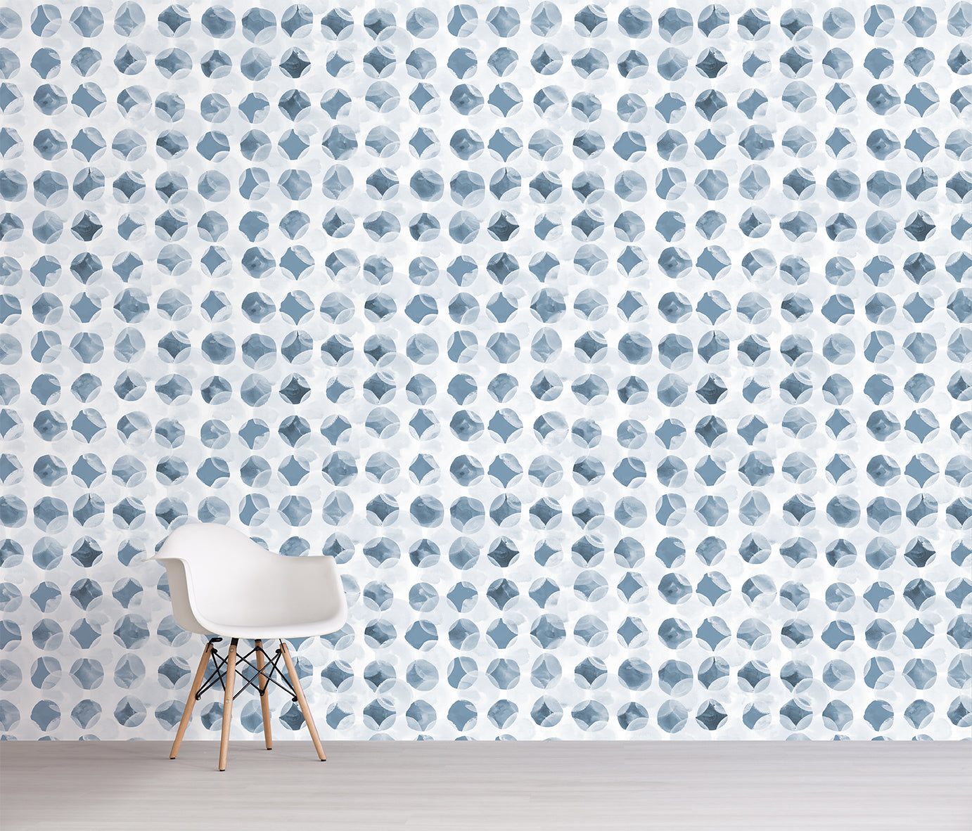 Room with a chair against a wall featuring a blue geometric pattern.