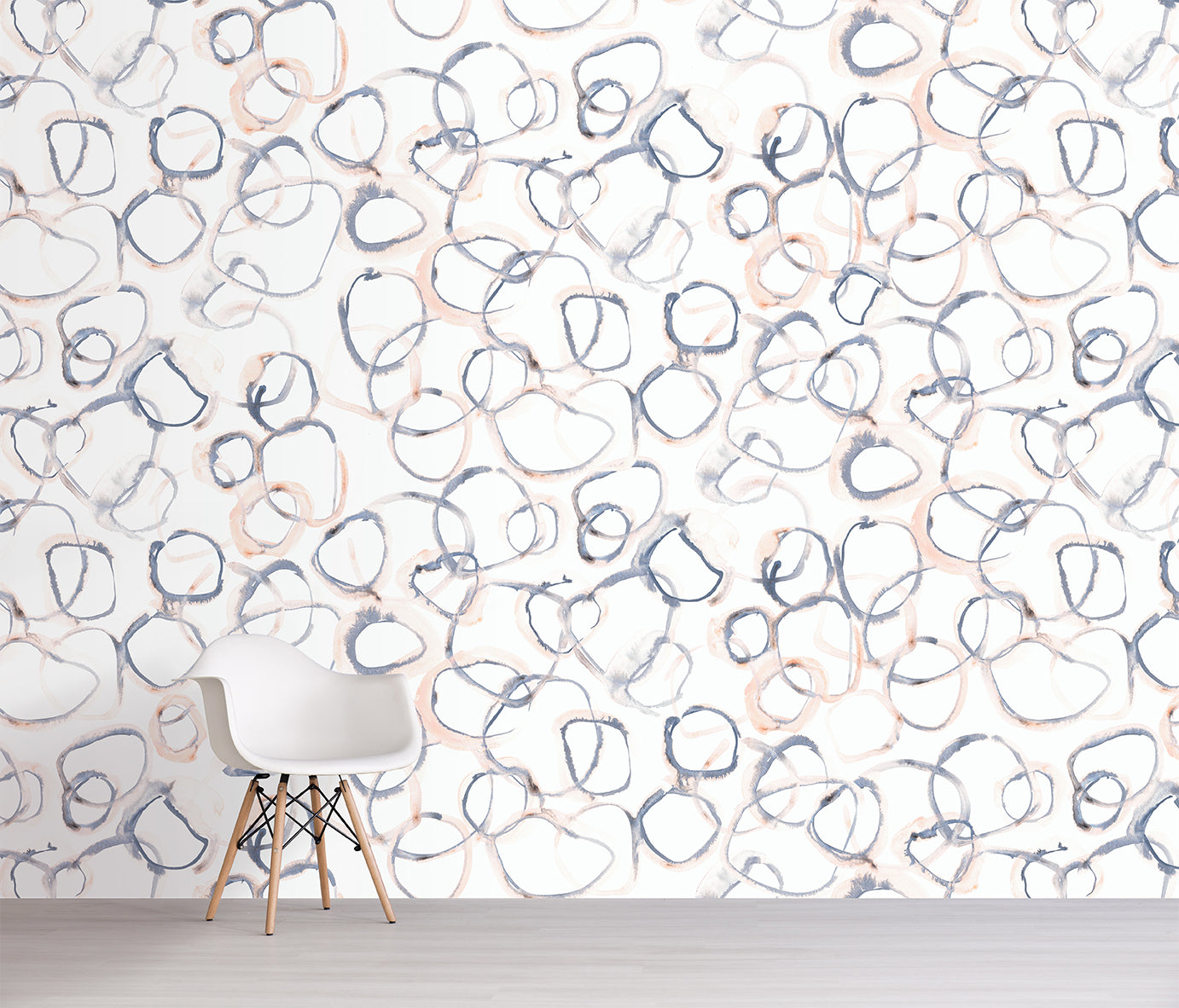 Wallpaper with abstract circular patterns in blue and orange on a white background, with a chair in front.