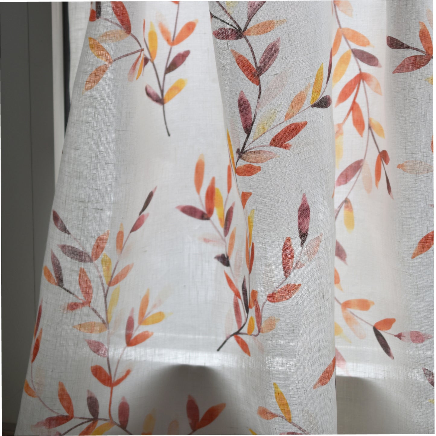 Sheer curtain with autumn leaf pattern on a white background