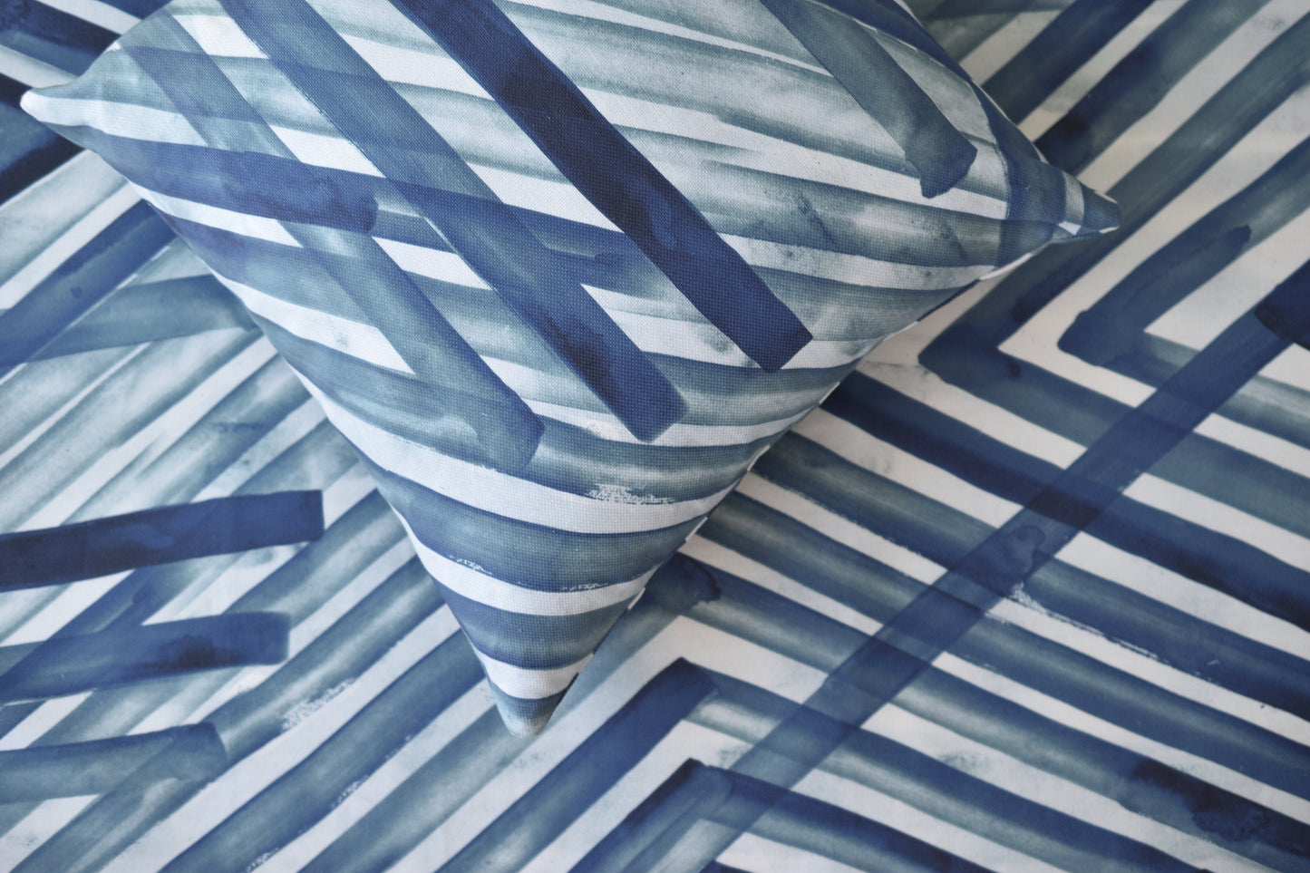 Blue and white striped fabric and pillow with a geometric pattern