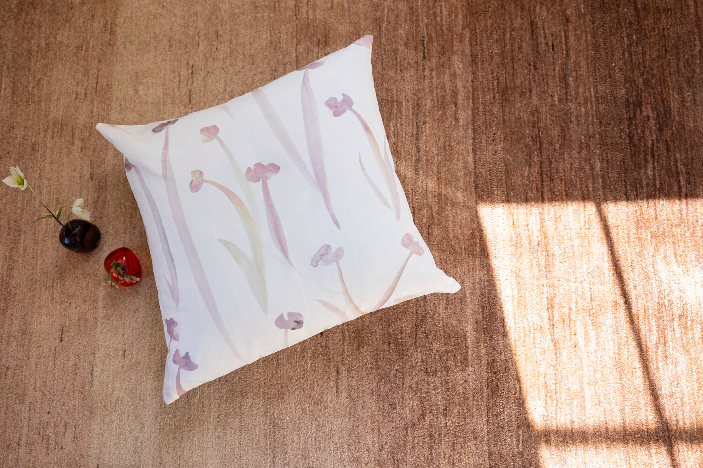 Decorative pillow with floral pattern on a rug surface