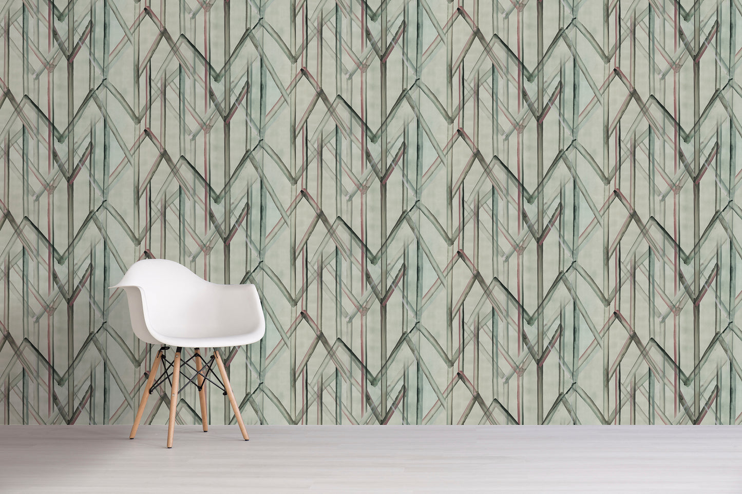 White chair in front of a wall with green geometric patterned wallpaper