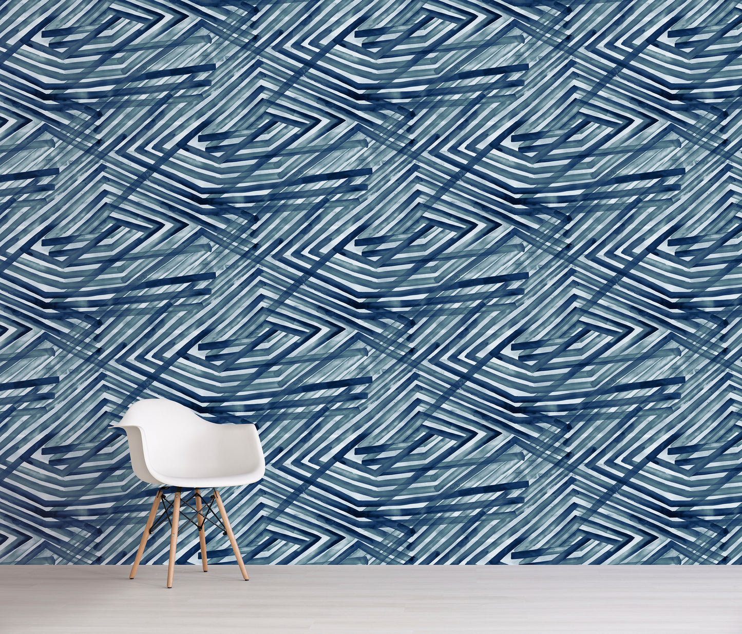 Room with a chair against a wall featuring a blue geometric pattern