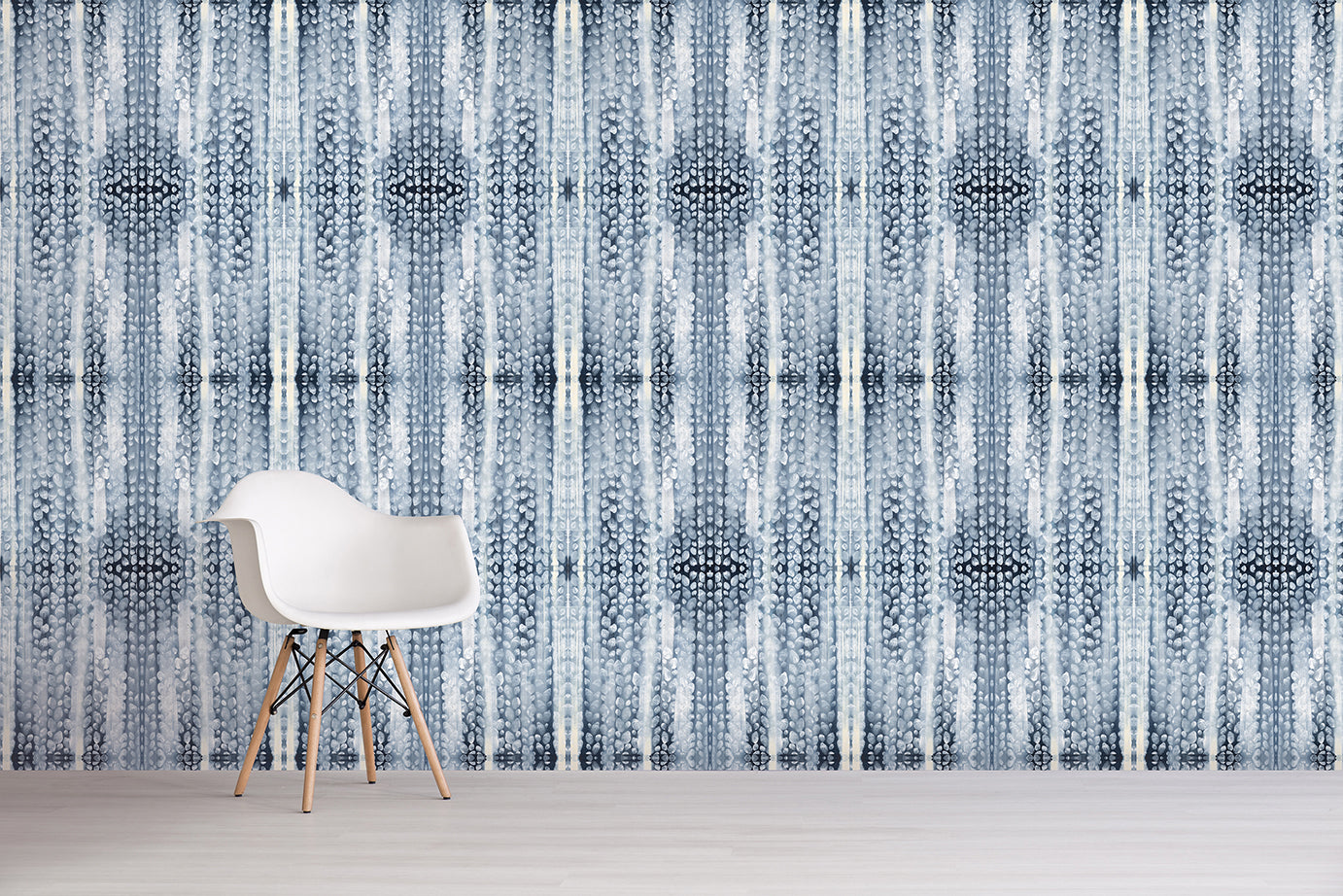 White chair in front of a patterned wall with vertical lines and blue geometric shapes.
