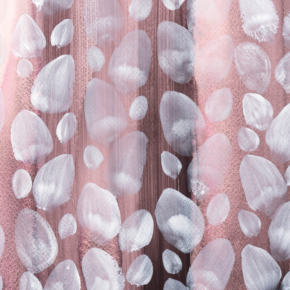 Close-up of white orb patterns on a pink background