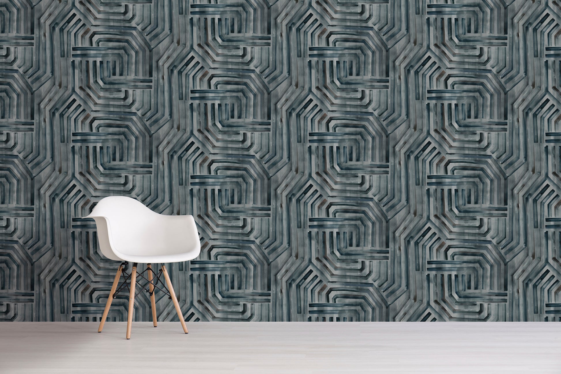 White chair in front of a textured gray wall with gray geometric pattern