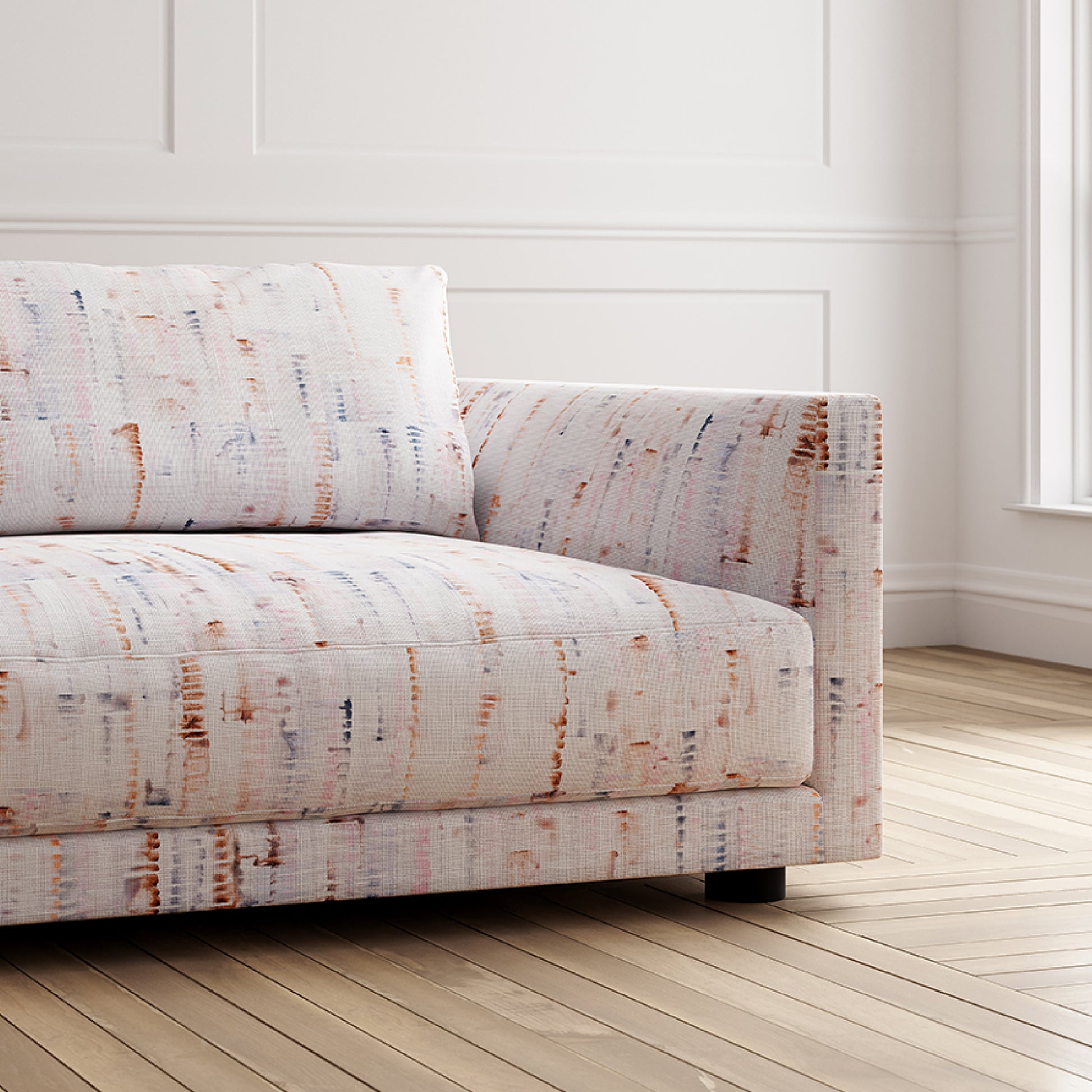 Patterned sofa in a room with wooden flooring and white walls