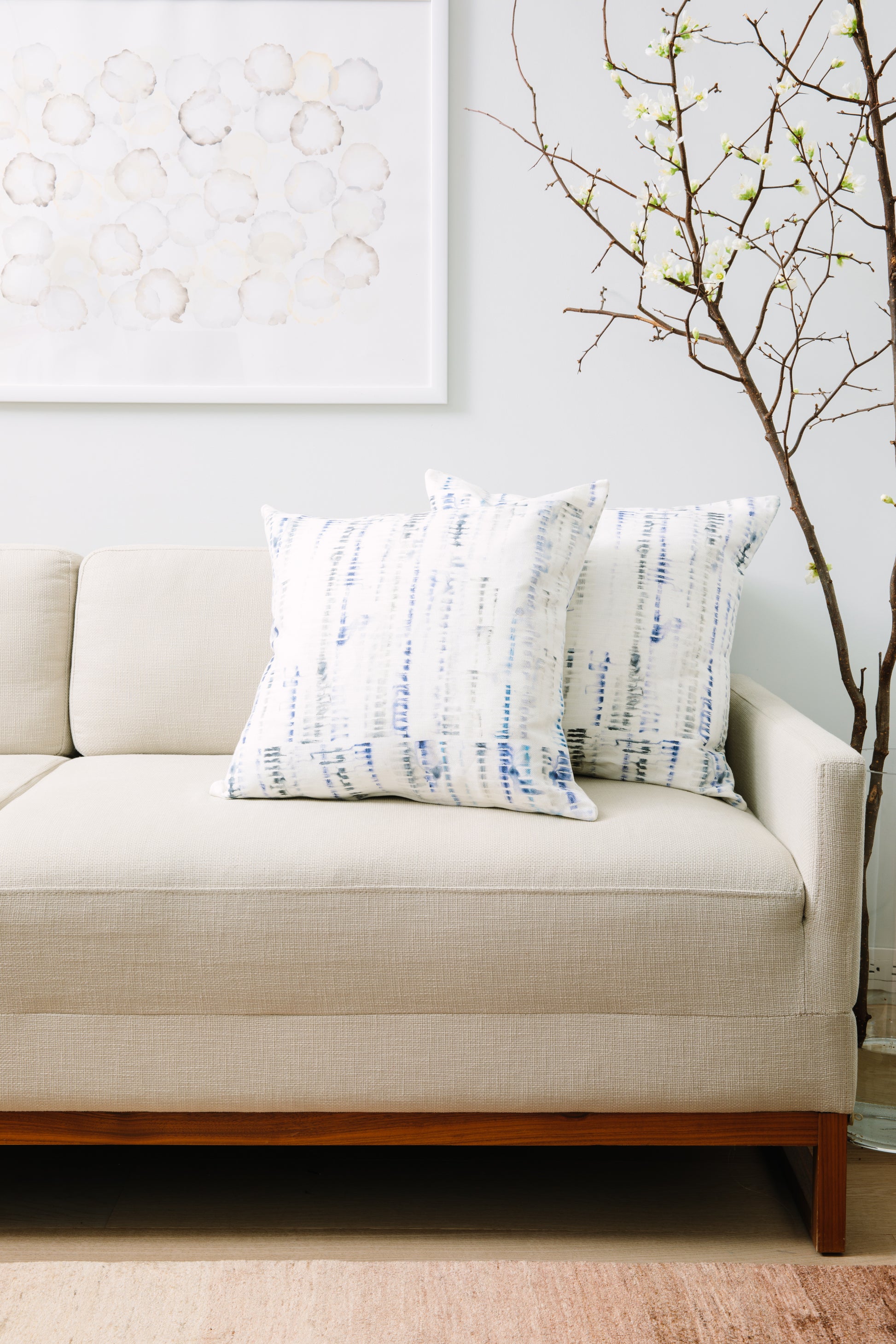 Beige sofa with patterned cushions in a living room setting