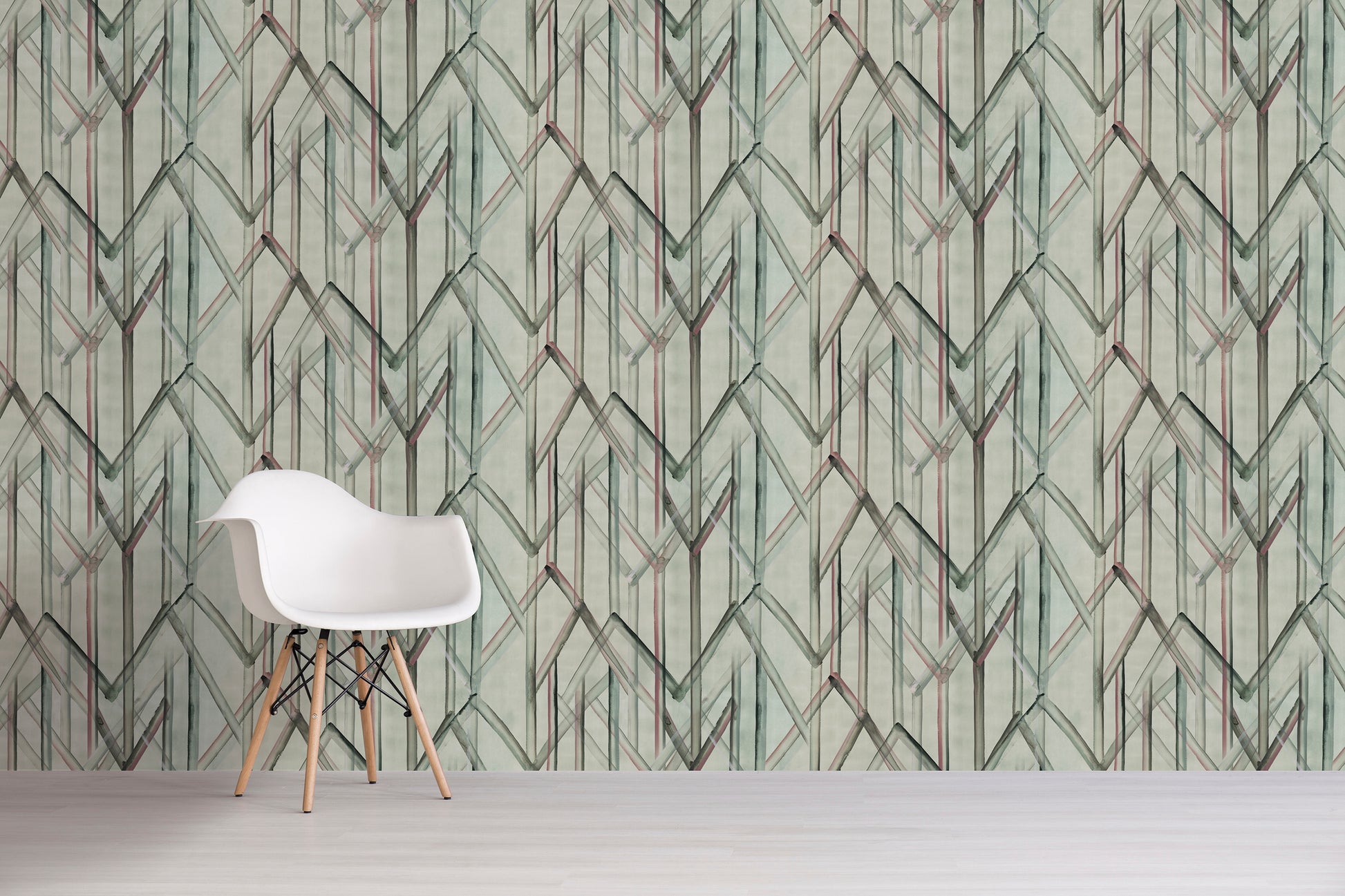 White chair in front of a wall with green geometric patterned wallpaper