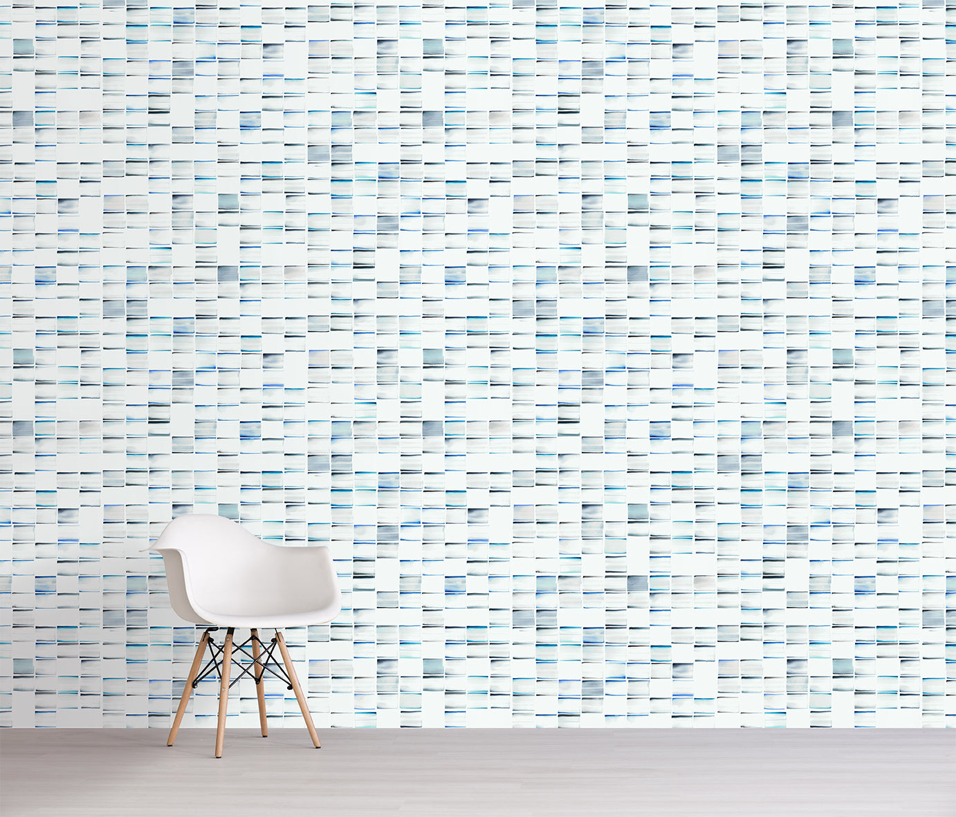 Wall with a pattern of small, horizontal tiles in various shades of blue and gray, featuring a chair in front.