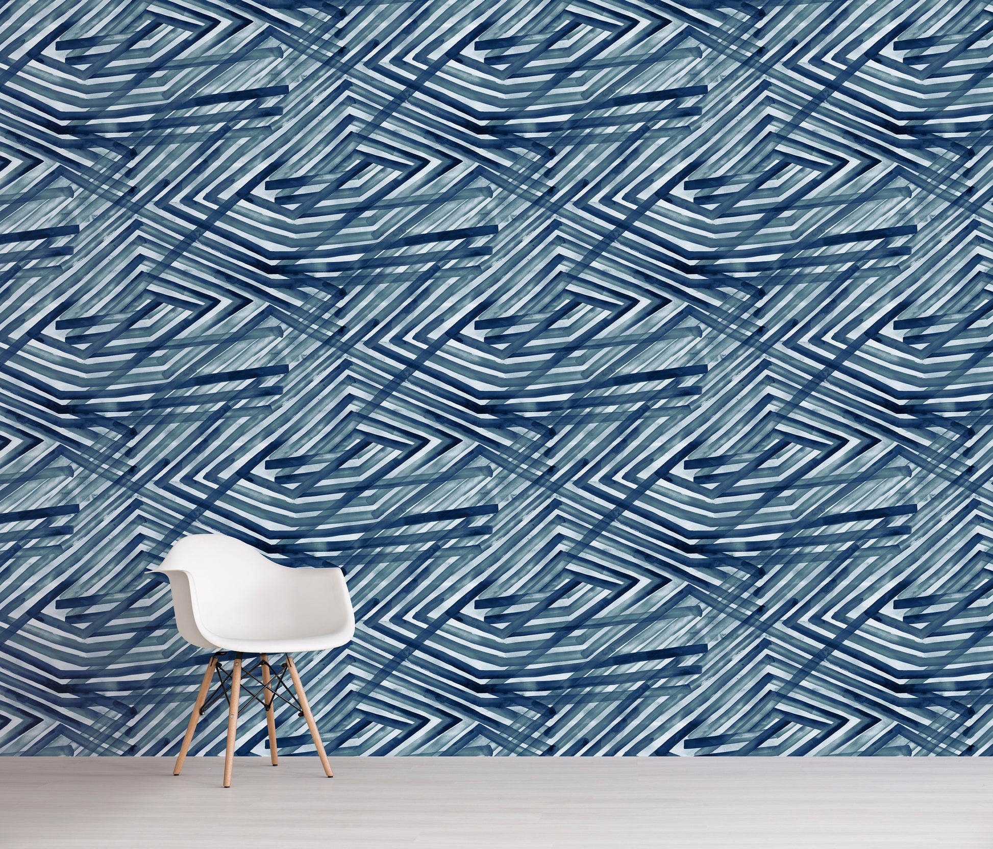 Room with a chair against a wall featuring a blue geometric pattern