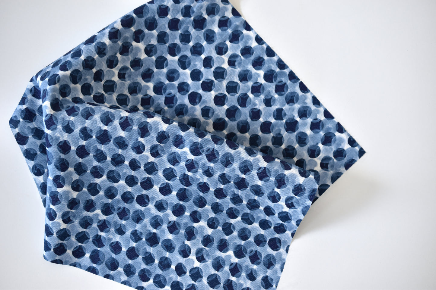 Blue polka dot fabric on a white background
