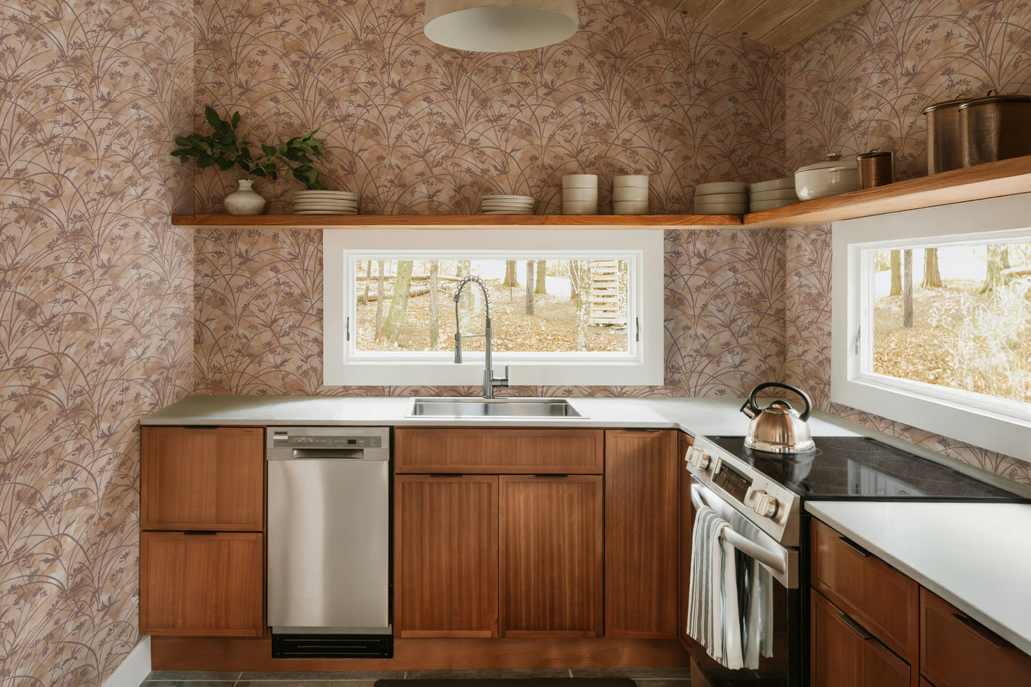 Modern kitchen with wooden cabinets, stainless steel appliances, and a window view.