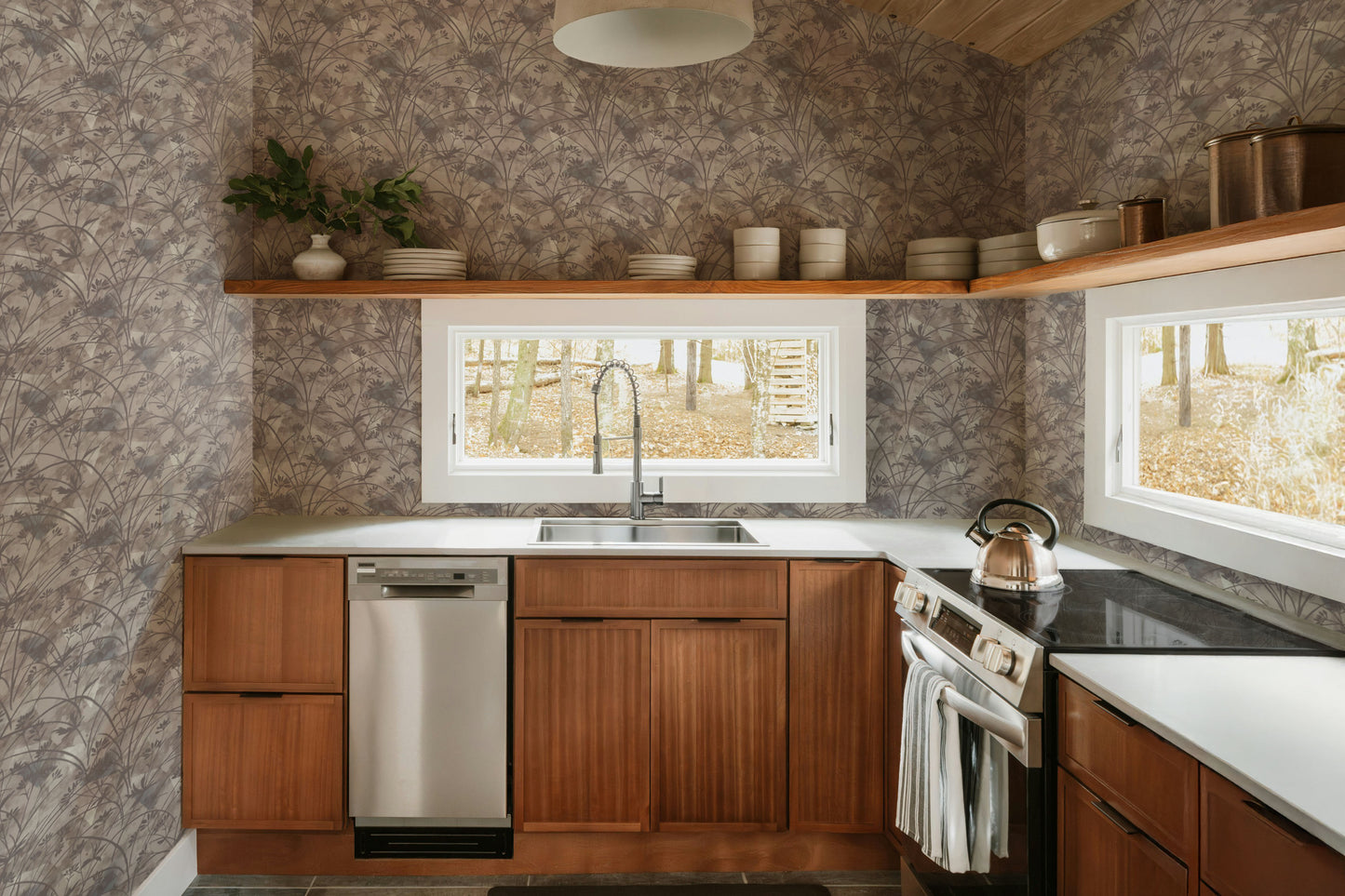 Modern kitchen with wooden cabinets, stainless steel appliances, and a wallpaper wall.