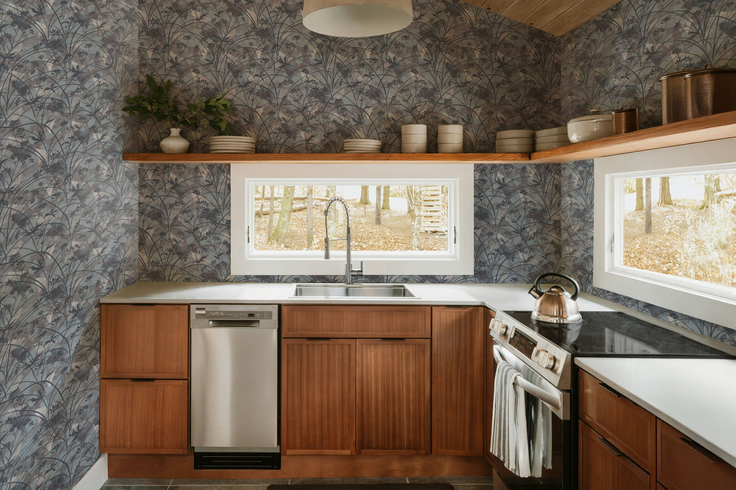 Modern kitchen with wooden cabinets, stainless steel appliances, and a wallpaper wall.