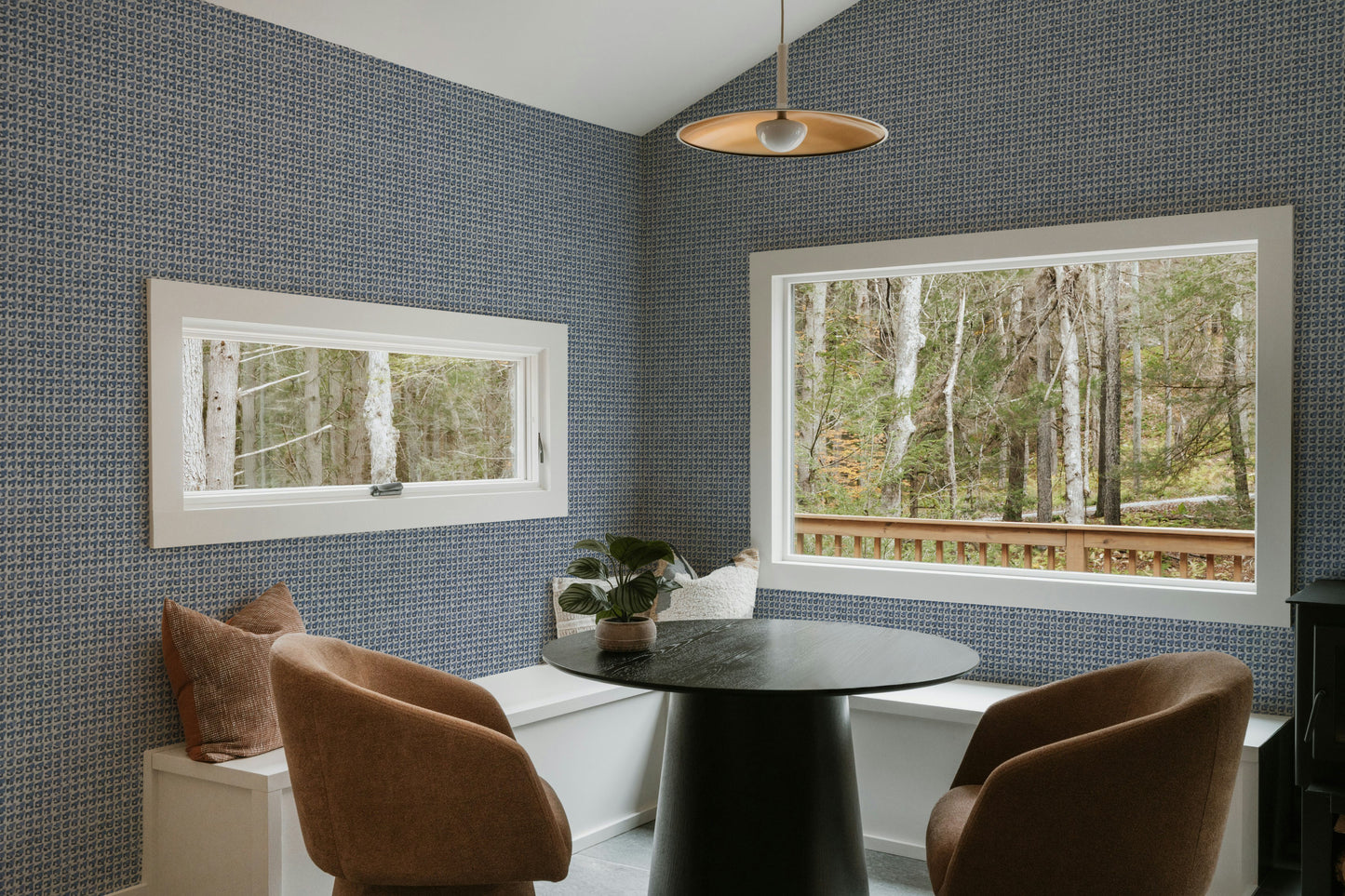 Modern dining room with a round table and chairs against a textured blue wall.