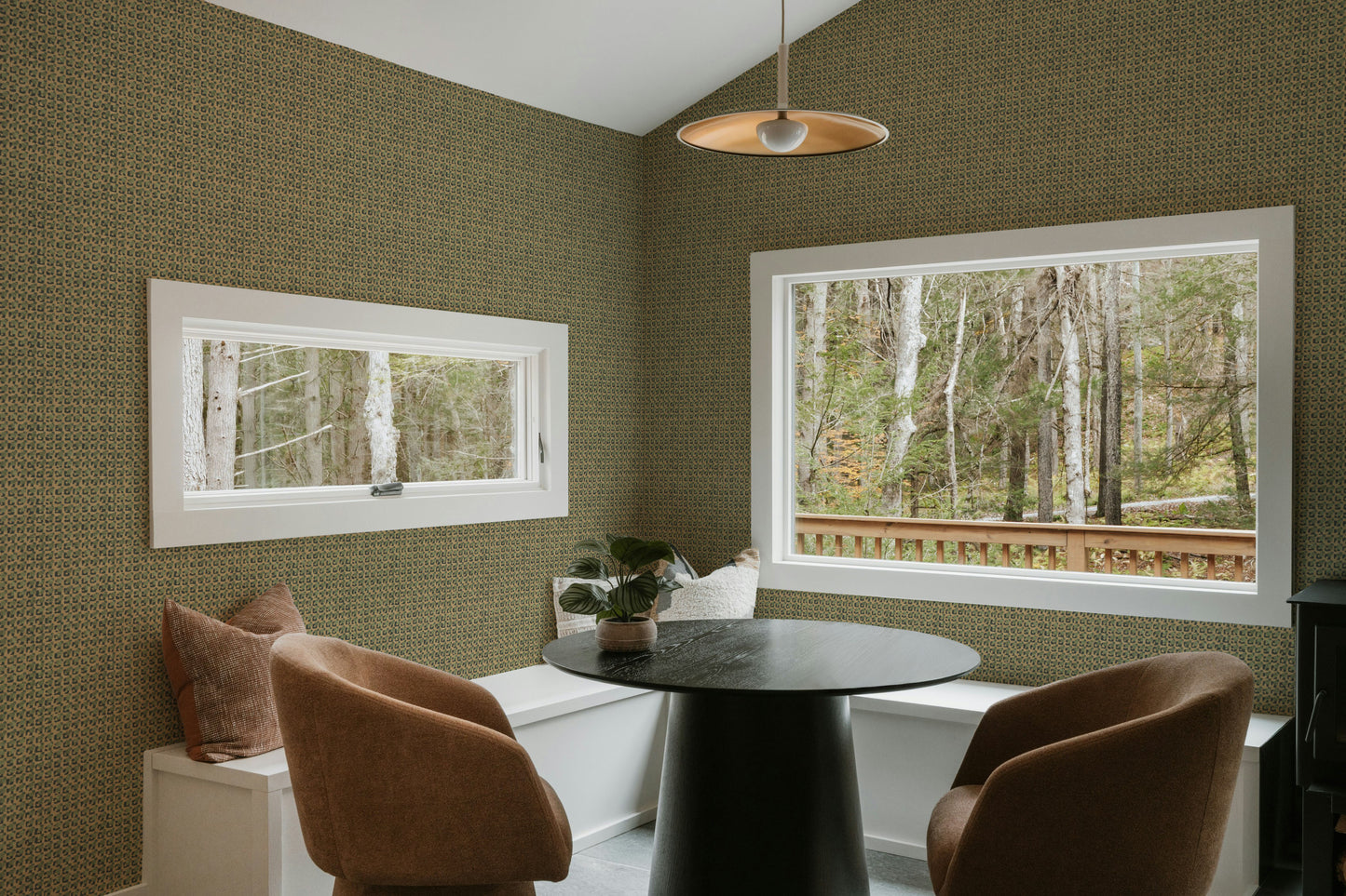 Dining room with green walls, a round table, and chairs.