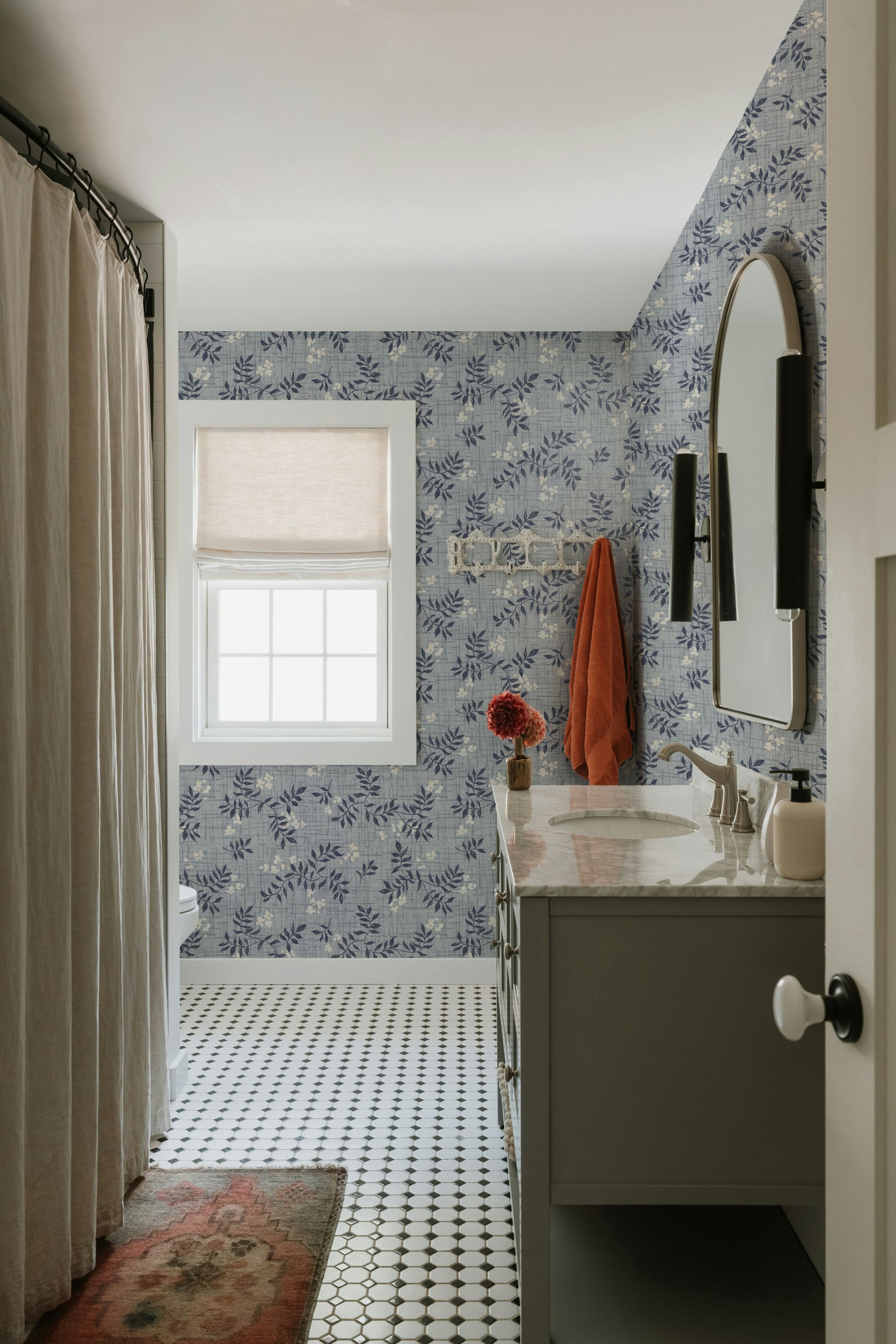 Bathroom with floral wallpaper, sink, and window