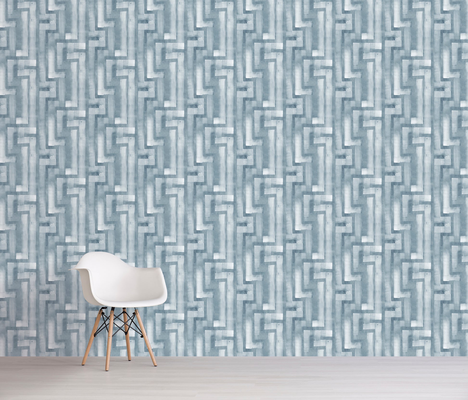 White chair in front of a blue geometric patterned wall.